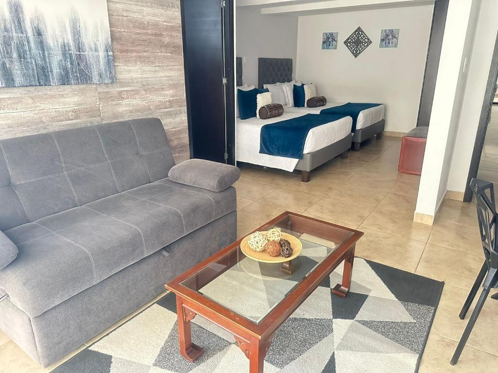 salon z kanapą i łóżkiem w obiekcie Hotel Alamos Del Parque w mieście Pereira