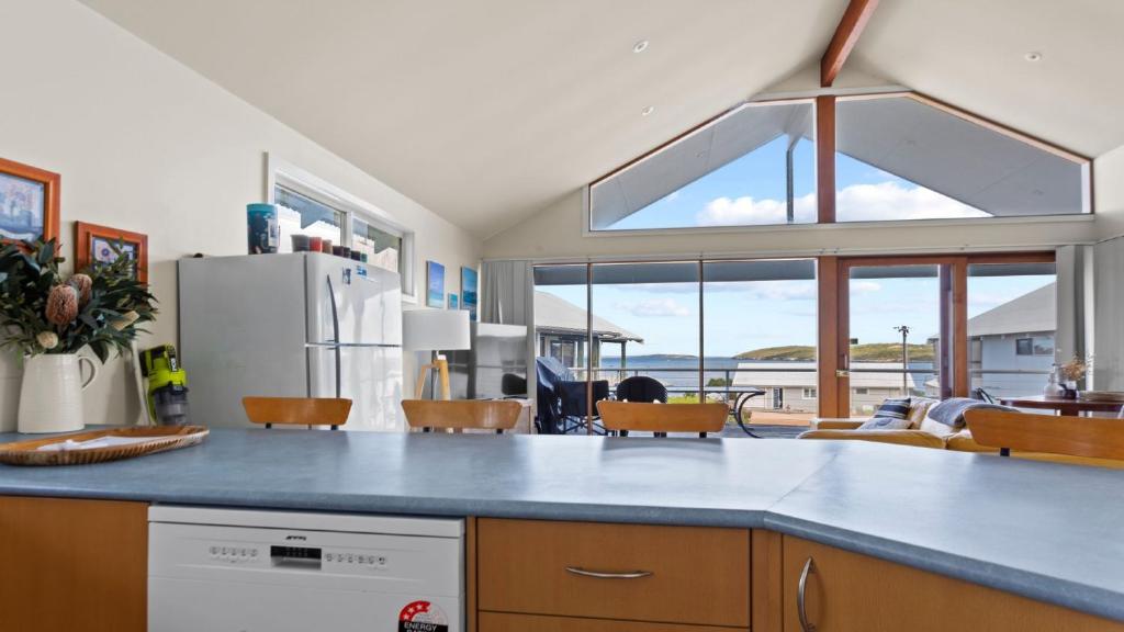 a kitchen with a blue counter top and a large window at Sheoak Holiday Home in Coffin Bay