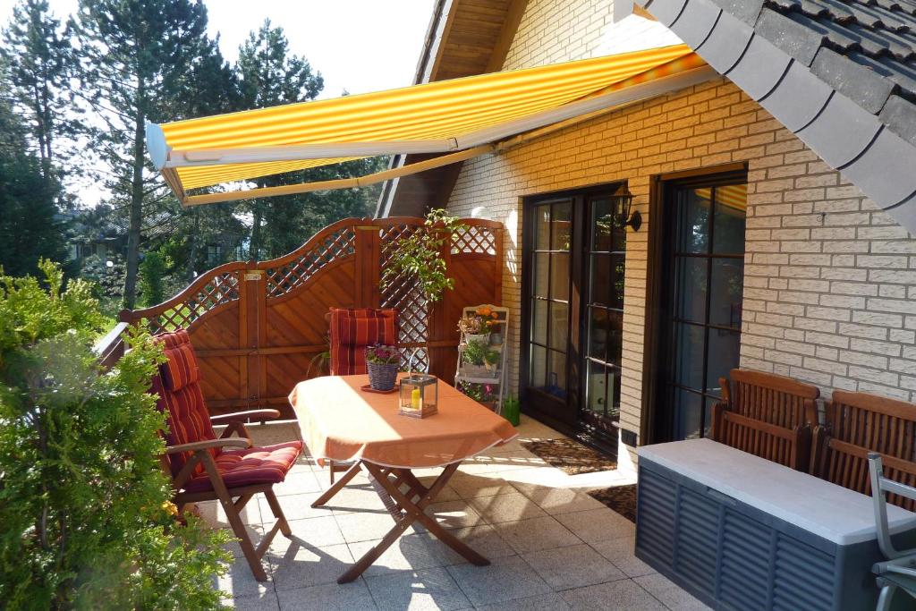 巴特明斯特艾弗爾的住宿－Ferienwohnung Orchidee，庭院配有桌椅和遮阳伞。