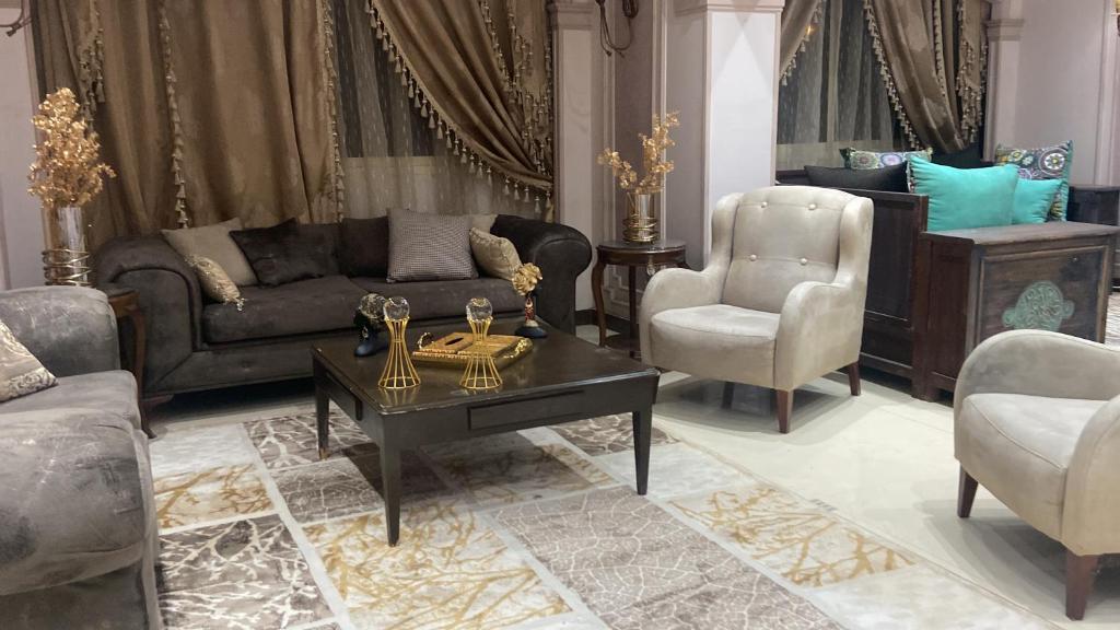een woonkamer met een bank en een tafel en stoelen bij Apartment for rent Zamalek in Caïro