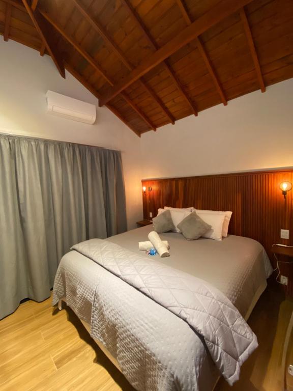 a bedroom with a large bed with a wooden headboard at Apartamento Avenida in Camanducaia