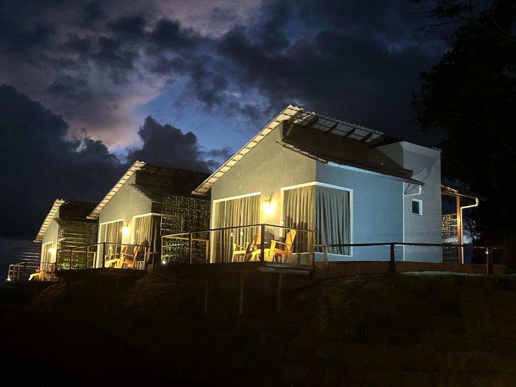 a house with a lit up facade at night at CORAÇÃO DO ALTO CHALES in Alto Caparao