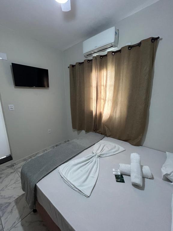 um quarto com uma cama com duas toalhas em Pousada Recanto Da Fé em Aparecida