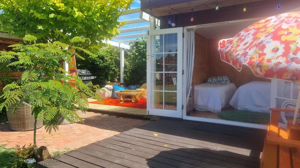 a room with an umbrella and a room with a bed at Delightful 1 bedroom tiny house, with retro Poptop in Westport