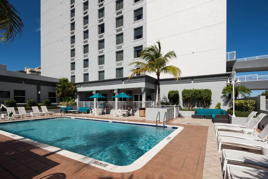 Una piscina con tumbonas y un hotel. en Hampton Inn Fort Lauderdale Downtown Las Olas Area, en Fort Lauderdale