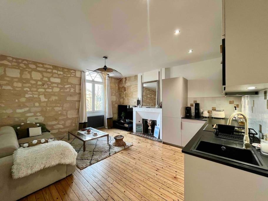 une cuisine et un salon avec un canapé et une table dans l'établissement Cosy appartement Bordeaux centre, à Bordeaux