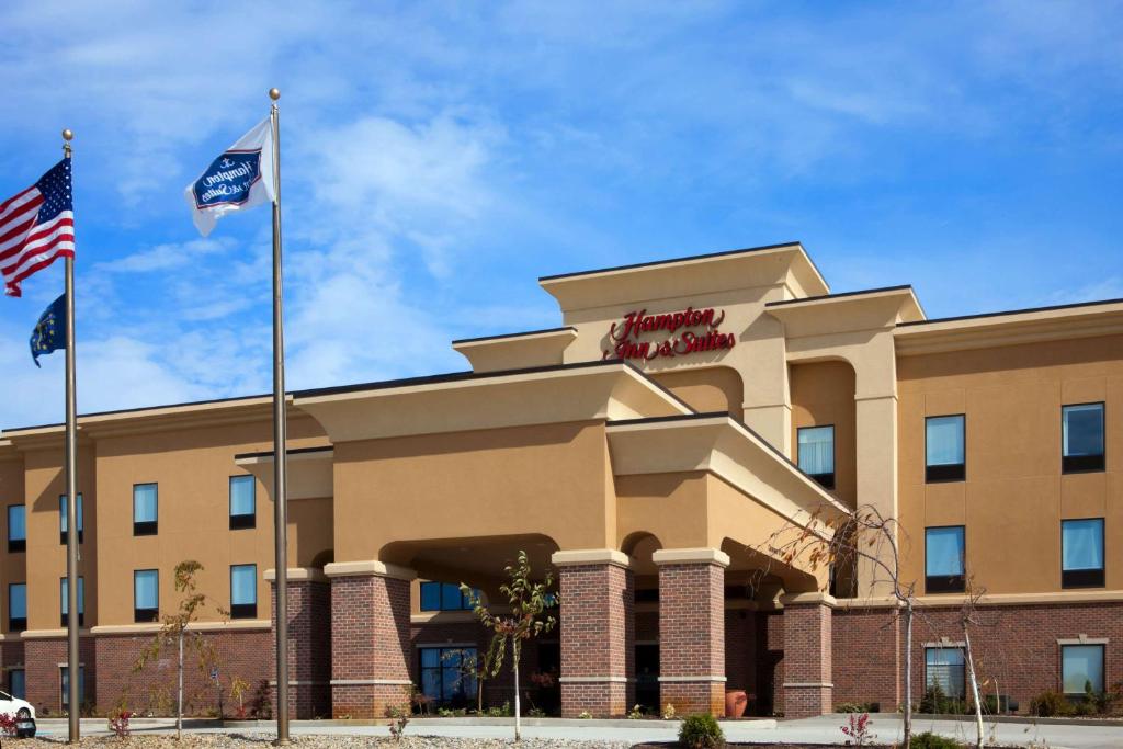 a hotel with two flags in front of it at Hampton Inn & Suites Middlebury in Middlebury