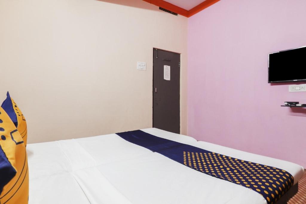 a bedroom with a bed and a tv on the wall at OYO Hotel 74966 Shree Amardeep Hotel in Hyderabad