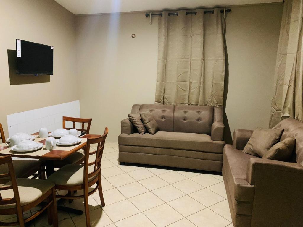 a living room with a couch and a table and a couch at La Casita in San Pedro Sula