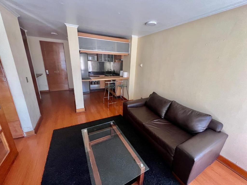 サンティアゴにあるDepartamento con ubicacion perfecta en las condesのリビングルーム(革張りのソファ、テーブル付)