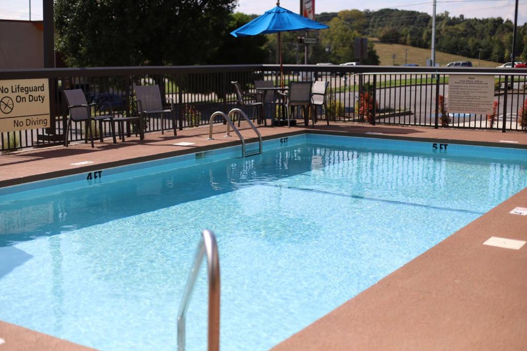 ein großer Pool mit Stühlen und einem Sonnenschirm in der Unterkunft Hampton Inn Greeneville in Greeneville