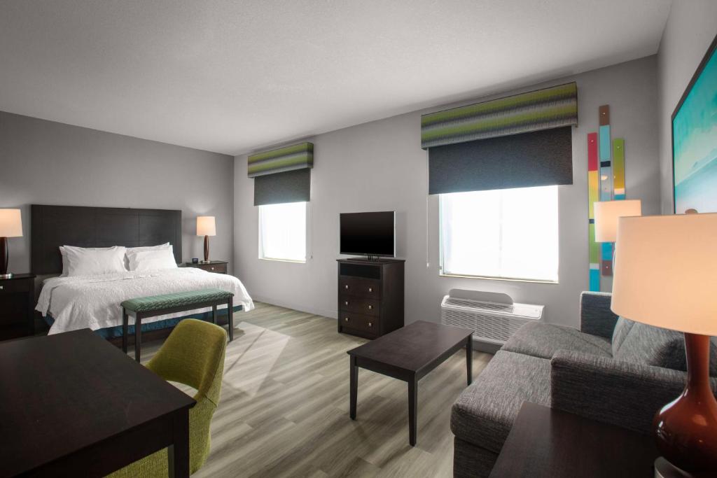 Hampton Inn & Suites Homestead Miami South في هومستيد: غرفه فندقيه بسرير واريكه