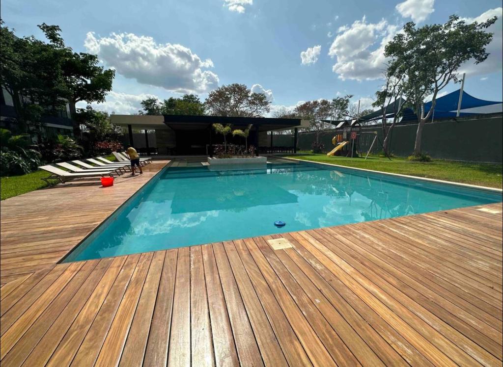 uma grande piscina com um deque de madeira em D2 Departamento Centrico Mérida em Mérida
