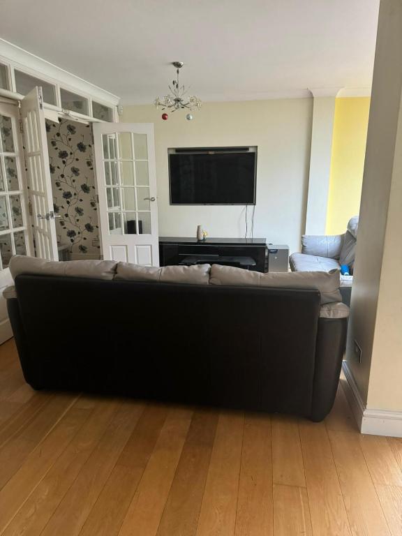 a living room with a couch and a flat screen tv at Krystal Residence in London