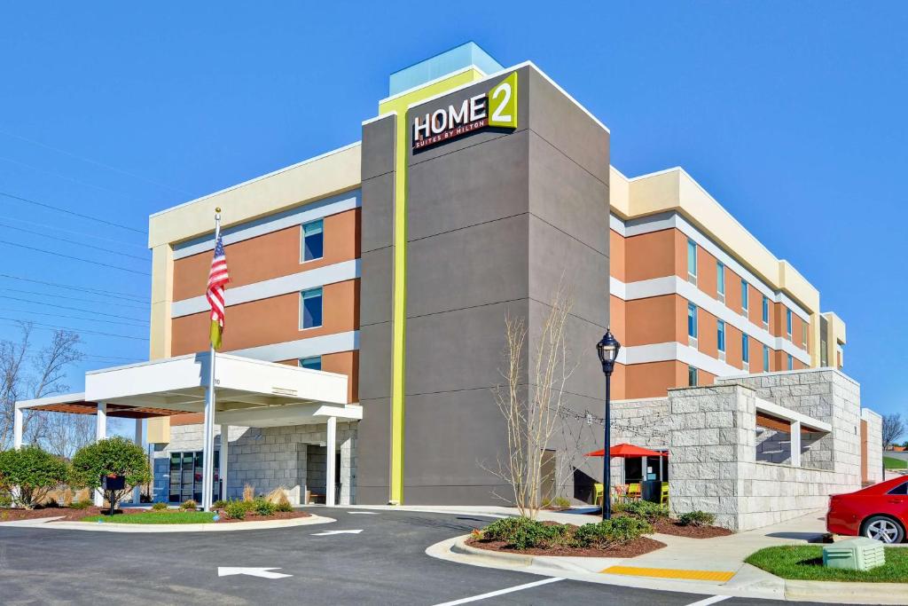 ein Hotelgebäude mit einem Schild, auf dem das Haus angezeigt wird in der Unterkunft Home2 Suites By Hilton Winston-Salem Hanes Mall in Winston-Salem