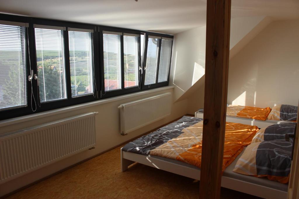 Ce lit se trouve dans un dortoir doté de 2 lits superposés et de fenêtres. dans l'établissement Ubytování U Starých, à Zaječí