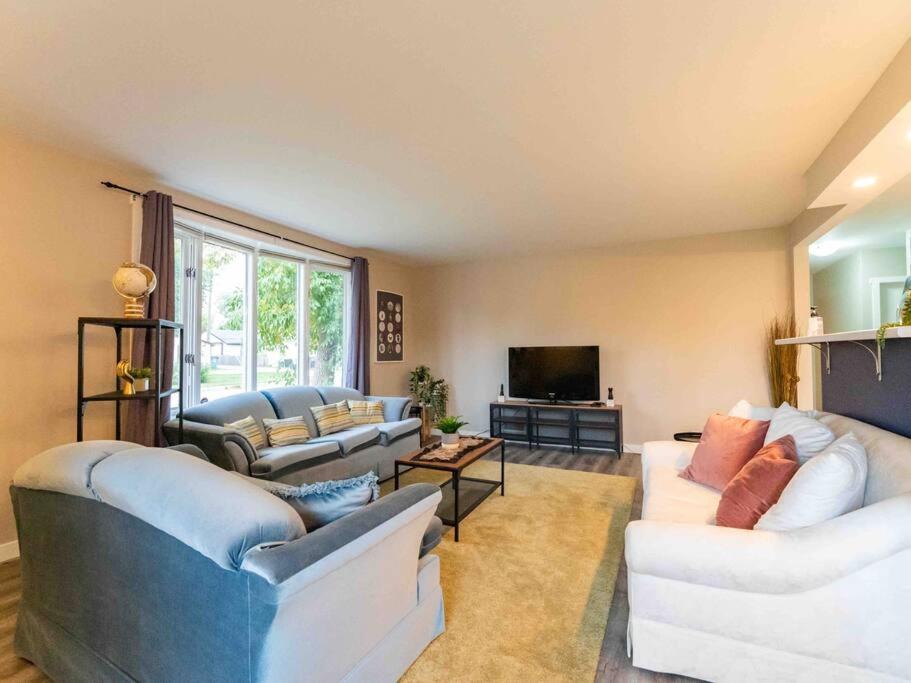 a living room with two couches and a tv at Modern and Spacious Home in St. Vital in Winnipeg