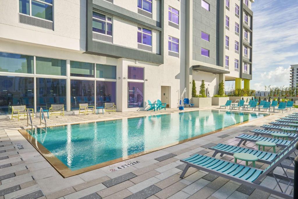 a swimming pool with lounge chairs in front of a building at Tru By Hilton Fort Lauderdale Downtown-Flagler Village in Fort Lauderdale