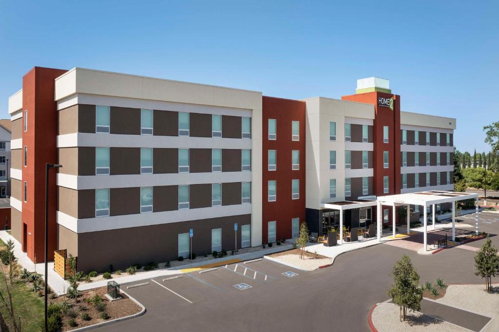 - une vue de tête sur un bâtiment avec un parking dans l'établissement Home2 Suites By Hilton Clovis Fresno Airport, à Clovis