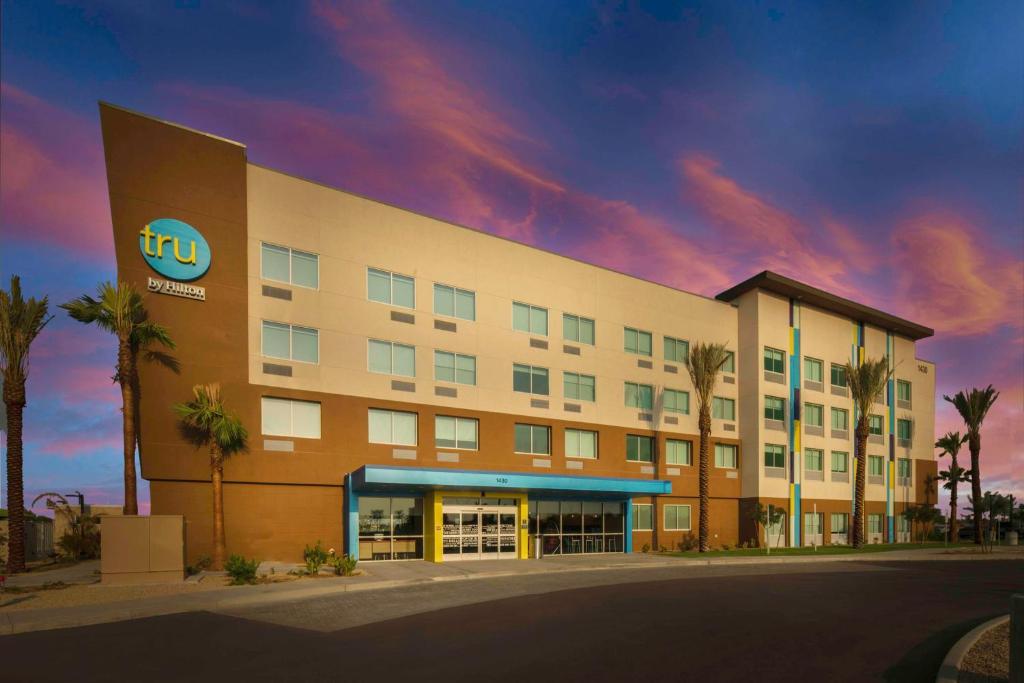 a building with a hotel with palm trees in front at Tru By Hilton Goodyear Phoenix West, Az in Goodyear