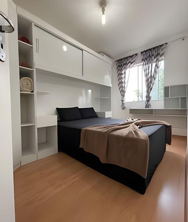 Un dormitorio con una cama grande y una ventana en Ap central 02 C/Ar Prox Centro en Feira de Santana