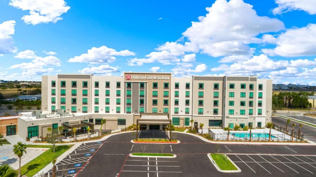 an exterior view of a hotel with a parking lot at Hilton Garden Inn Harlingen Convention Center, Tx in Harlingen