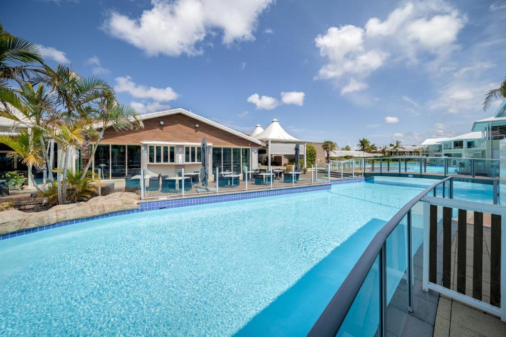 a large swimming pool on the balcony of a resort at Oaks Port Stephens Pacific Blue Resort in Salamander Bay