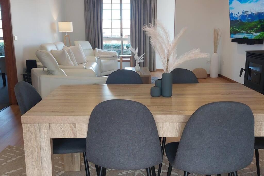 een woonkamer met een houten tafel en stoelen bij Valentine House in Hadspen