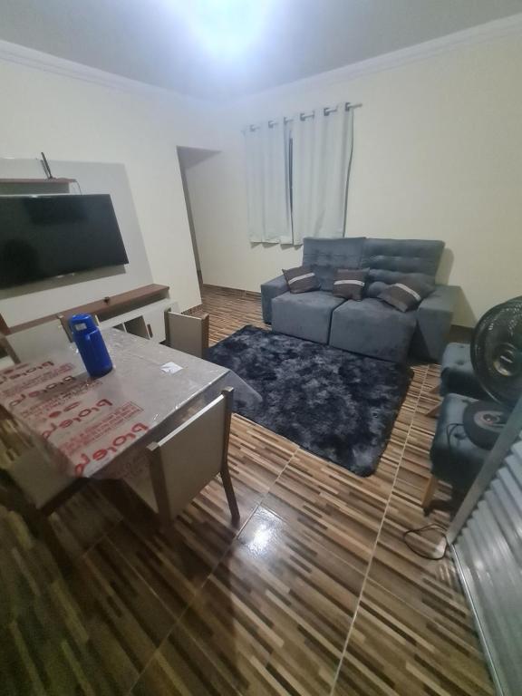 uma sala de estar com um sofá e uma mesa em Casa mobiliada para descanso e com piscina para o lazer há 5 min do aeroporto em Bayeux