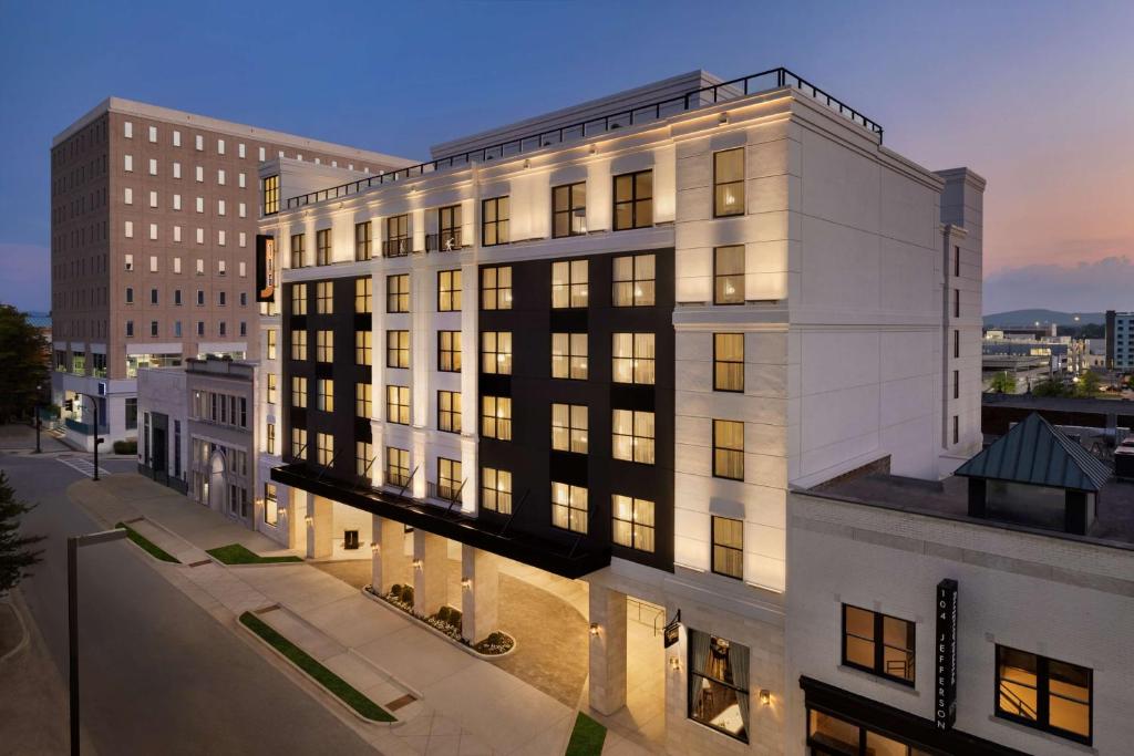 a large white building with windows on a city street at 106 Jefferson Huntsville, Curio Collection by Hilton in Huntsville