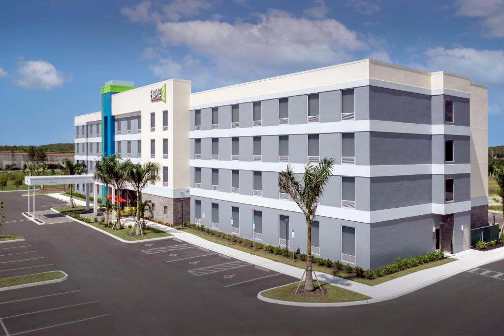 an image of a office building with a parking lot at Home2 Suites by Hilton Fort Myers Airport in Fort Myers