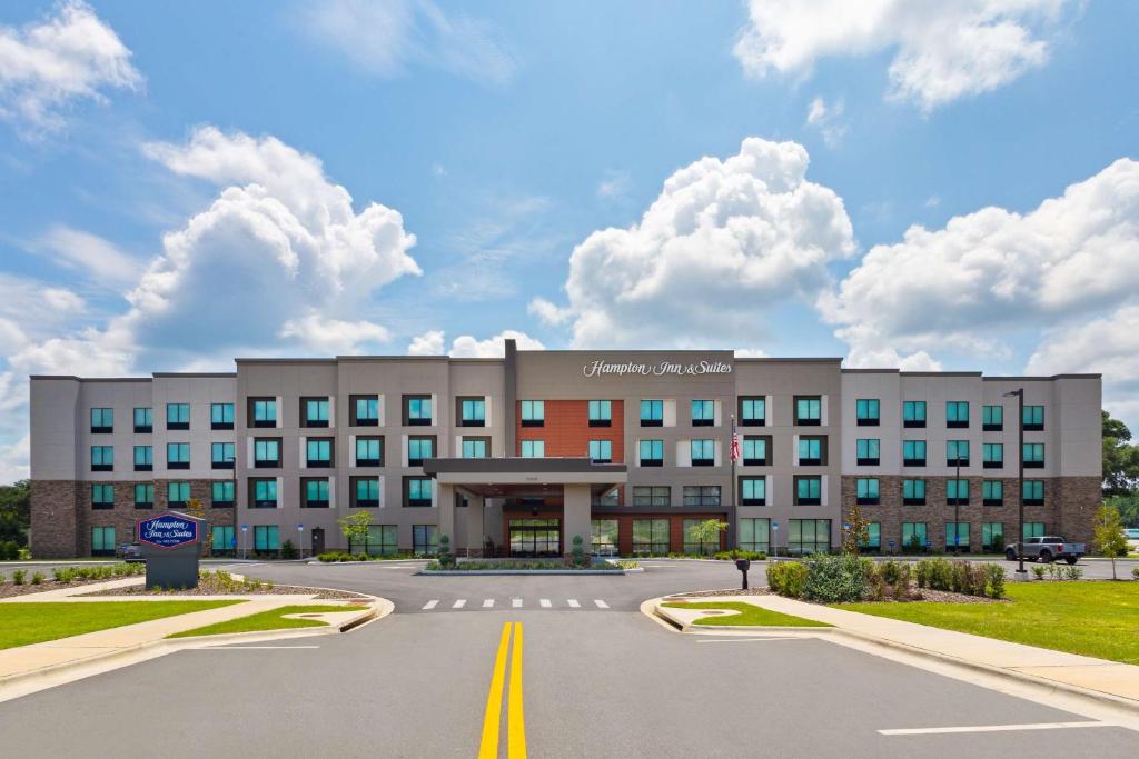 Hampton Inn & Suites Alachua I-75, FL في ألاتشوا: مبنى كبير وامامه موقف سيارات