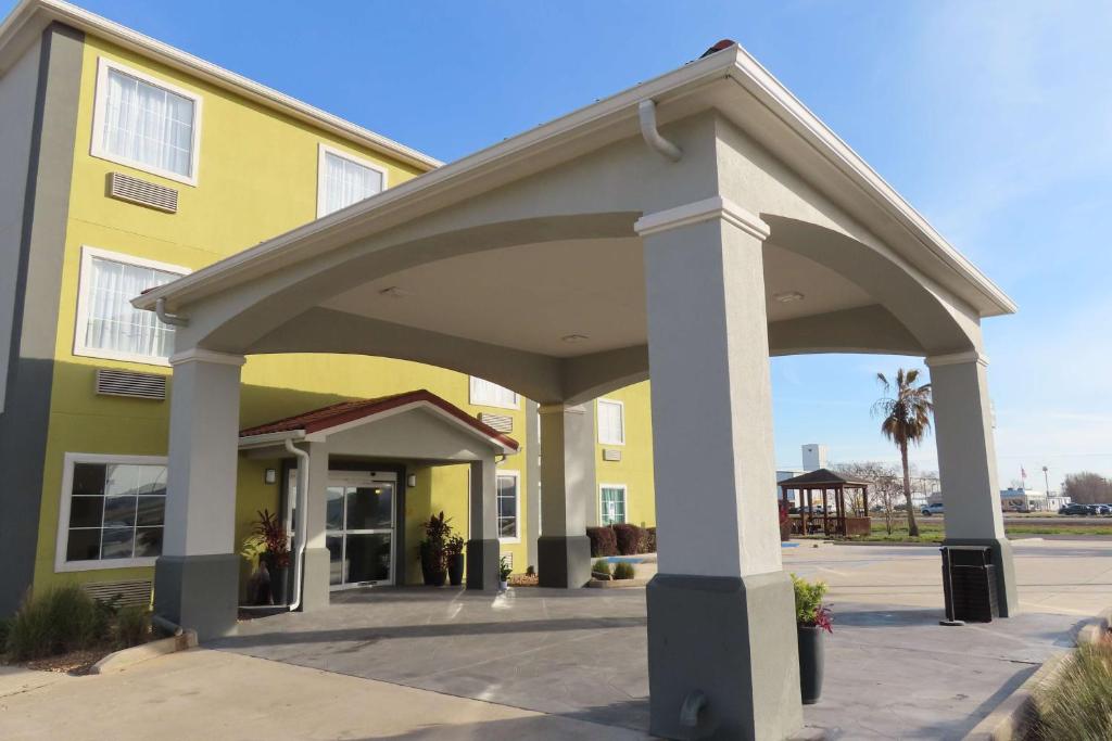 a large yellow building with a large roof at Best Western Heritage Inn & Suites in Broussard