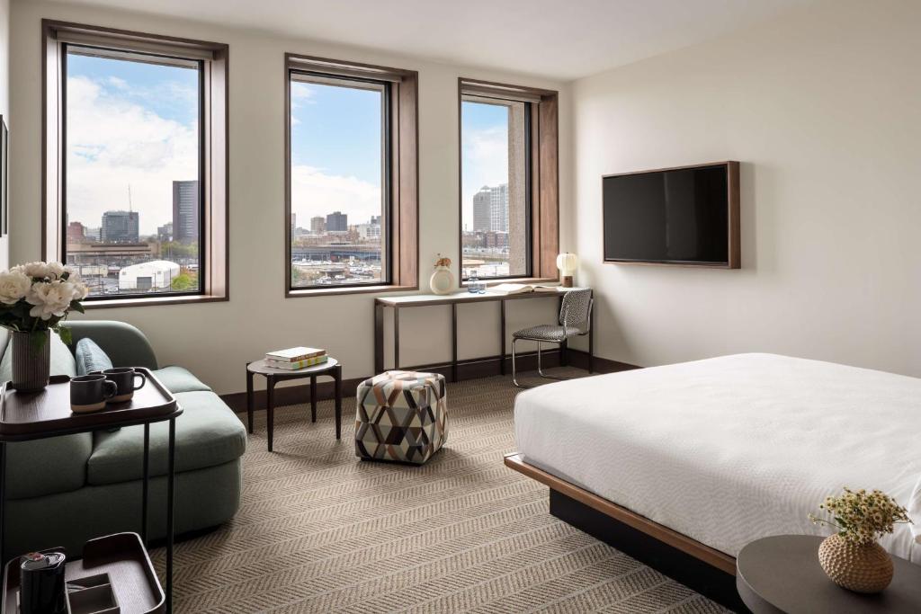 een hotelkamer met een bed, een bureau en ramen bij Hotel Marcel New Haven, Tapestry Collection By Hilton in New Haven