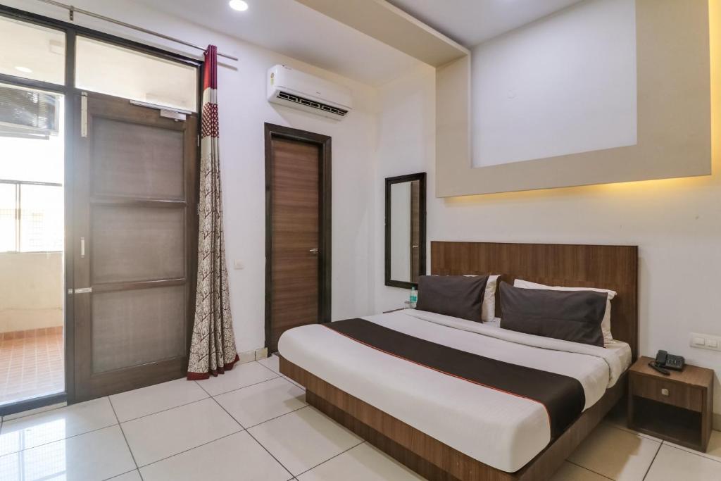 a bedroom with a large bed and a sliding glass door at Collection O Collection O Green Plaza Near Inox Gurgaon Dreamz in Gurgaon