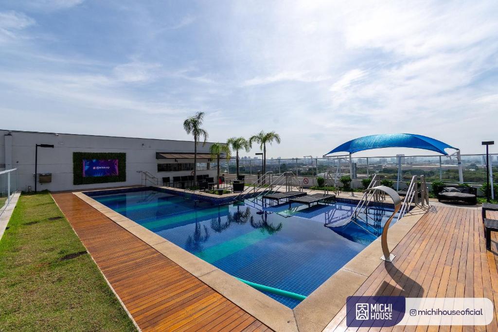 uma grande piscina com um guarda-sol num edifício em MH 50314 - Perfeito Studio Expo CN WF/AC/VG em São Paulo