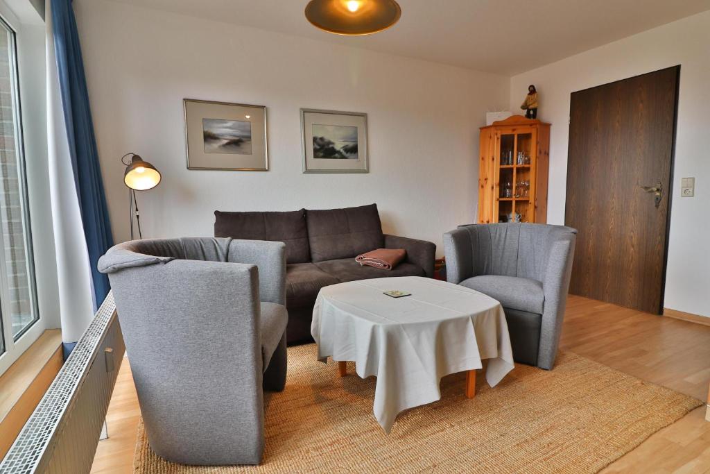 a living room with a couch and chairs and a table at Seemannskojen Backbord in Langeoog