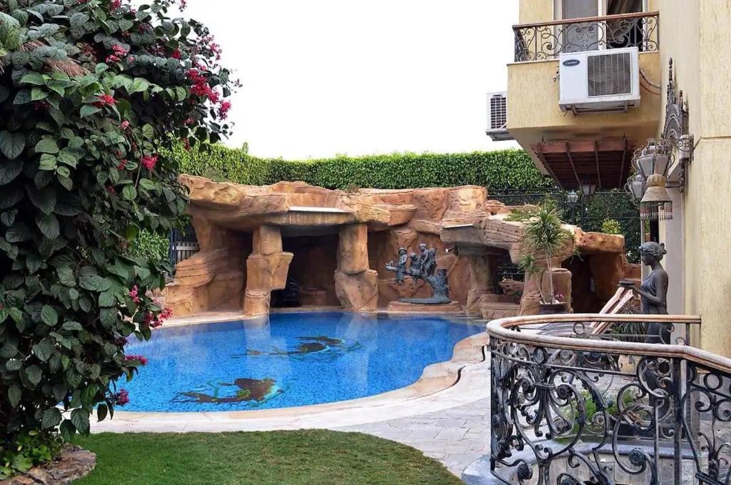 una pequeña piscina con cascada en un patio en Luxury Villa in Rehab City en El Cairo