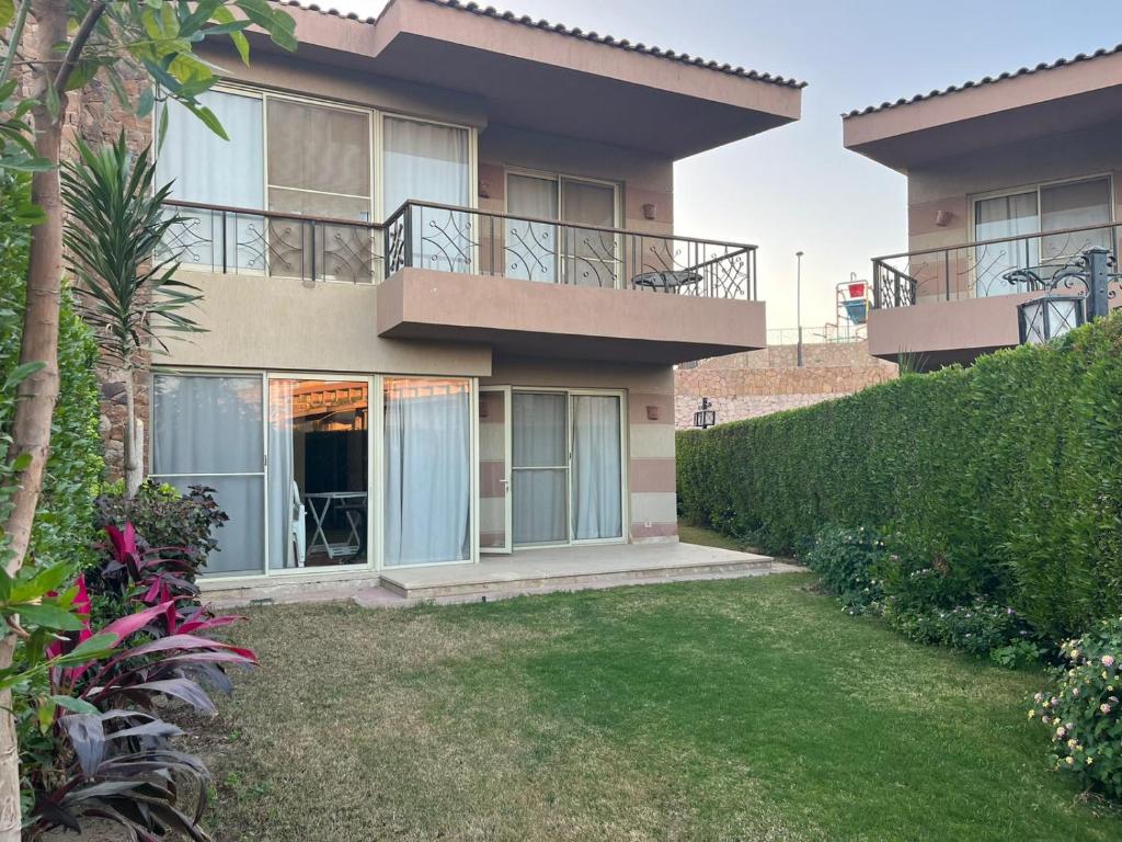 a house with a balcony and a yard at شالية ارضى مميز فى السخنة in Ain Sokhna