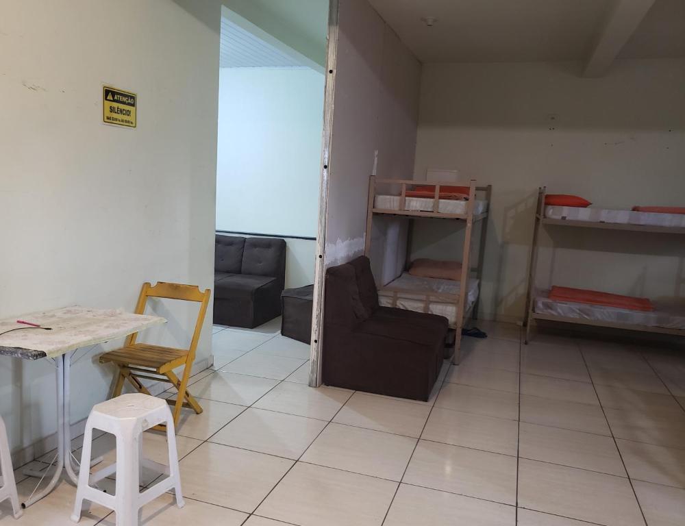 a room with a room with a table and chairs at Hostel O Vencedor in São Paulo