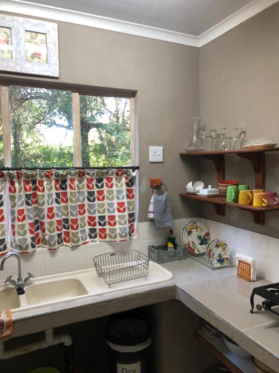 a kitchen with a sink and a window at Lebombo Wattle Cottage - Forest 1 in Hluhluwe