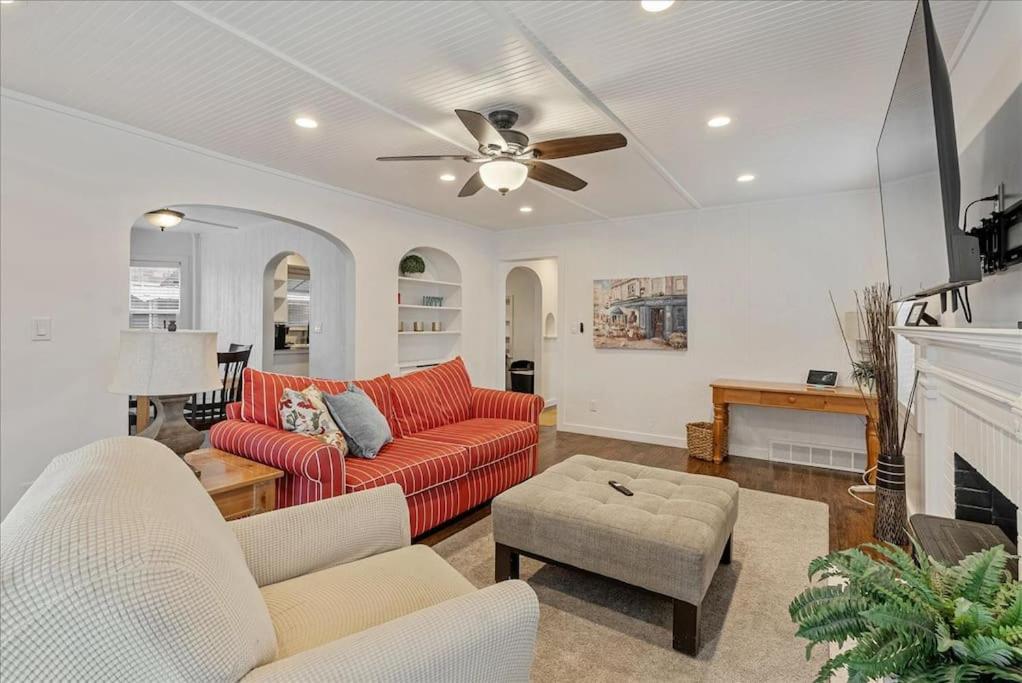 a living room with a red couch and a ceiling fan at Located in the heart of Provo Right off i15 in Provo