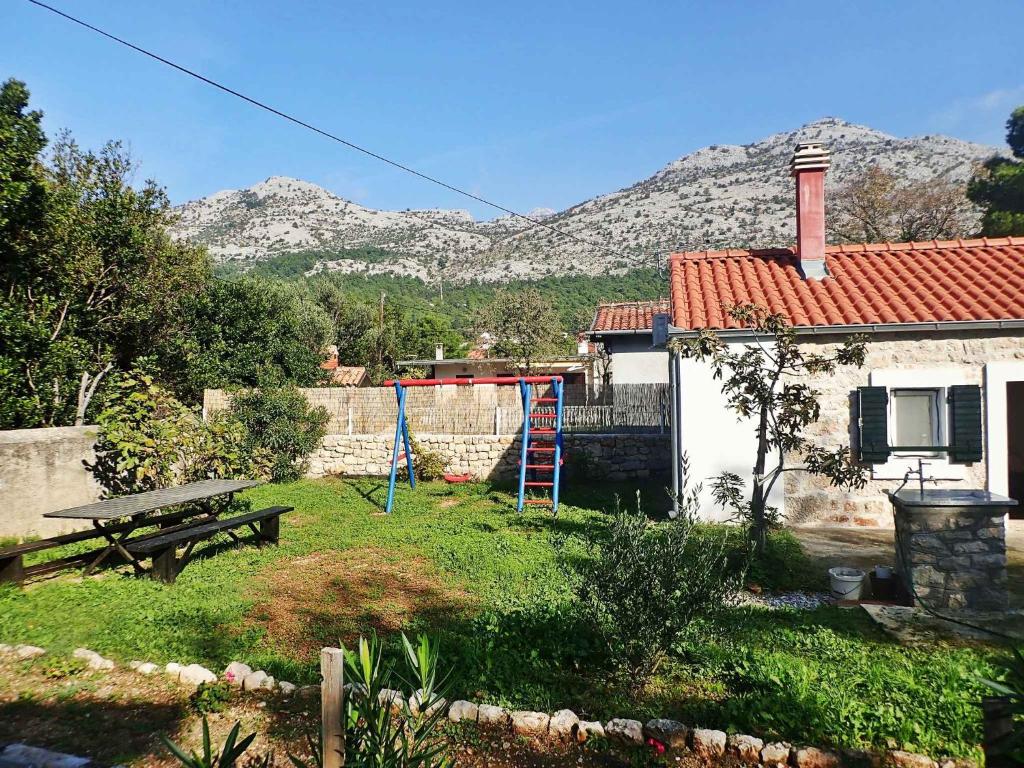 a yard with a picnic table and a house at Holiday home in Starigrad-Paklenica 40978 in Starigrad-Paklenica