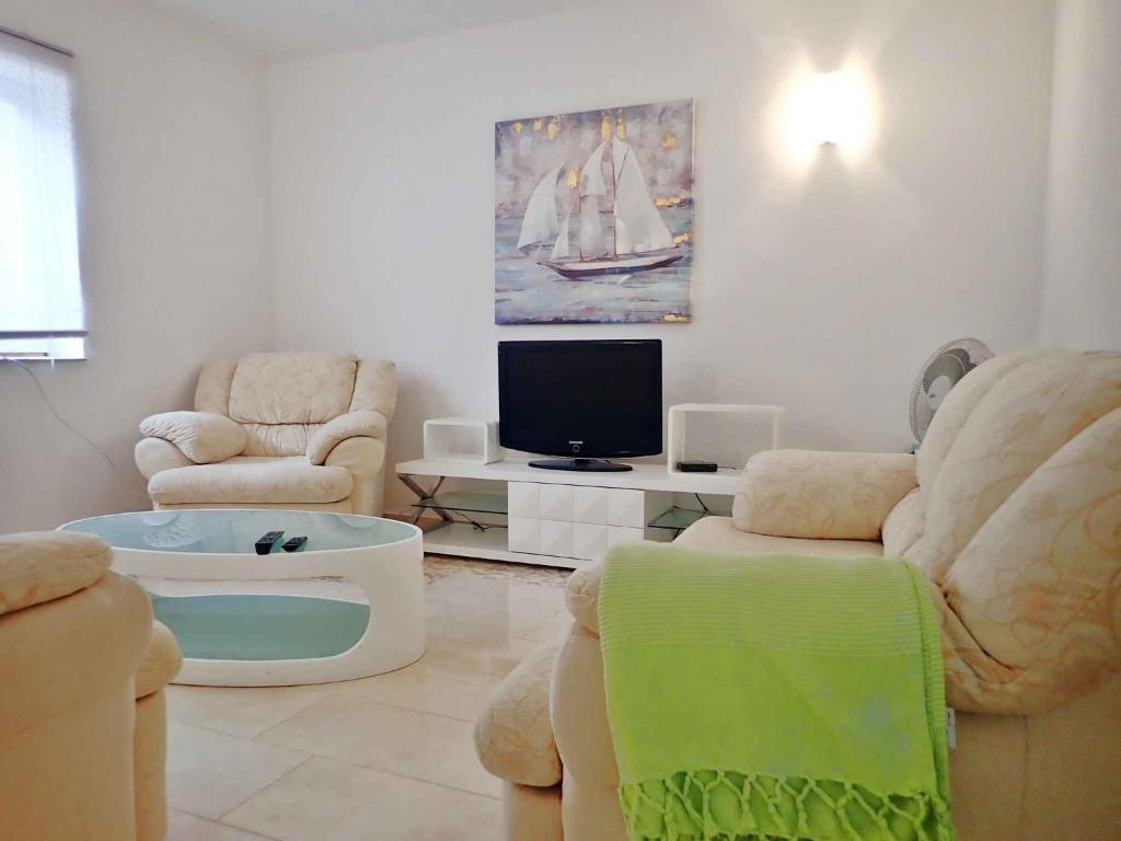 salon z 2 krzesłami i telewizorem w obiekcie Apartment in Starigrad-Paklenica 34801 w mieście Starigrad-Paklenica
