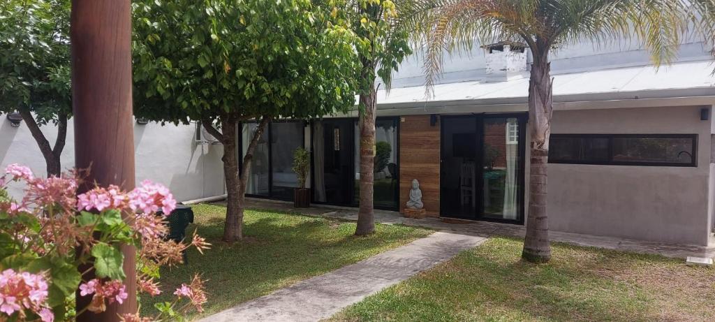 una casa con palmeras delante en Tatitos Homes El Pinar - Apartamento vacacional -, en Ciudad de la Costa