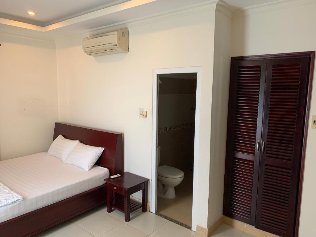 um quarto com uma cama e um WC. em Nhu Ngoc Homestay em Ấp Thiện Phước