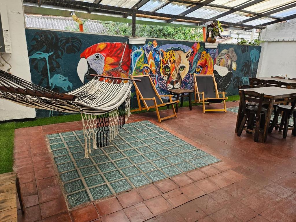 a room with a hammock and tables and a mural at Casa Samor La Candelaria in Bogotá