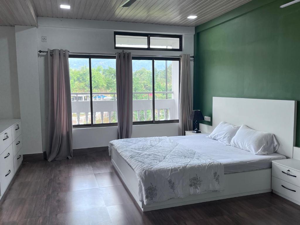 una camera con un grande letto e una grande finestra di BKR Homestay 1BH a Itānagar