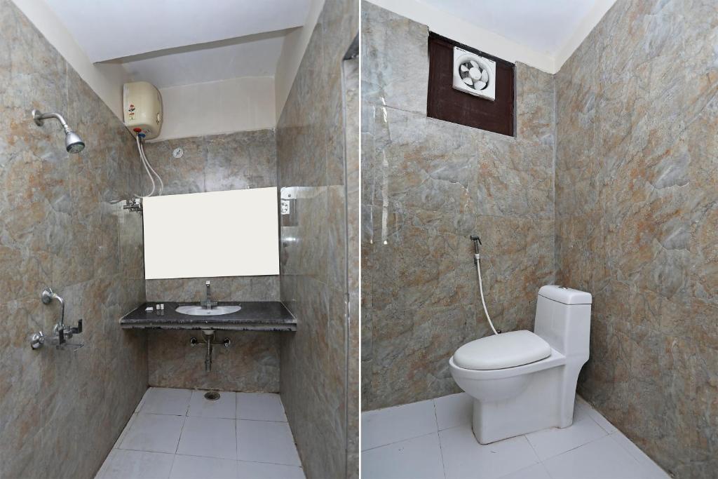 een badkamer met een toilet en een glazen douche bij OYO Hotel Shanti Palace in Sikandra
