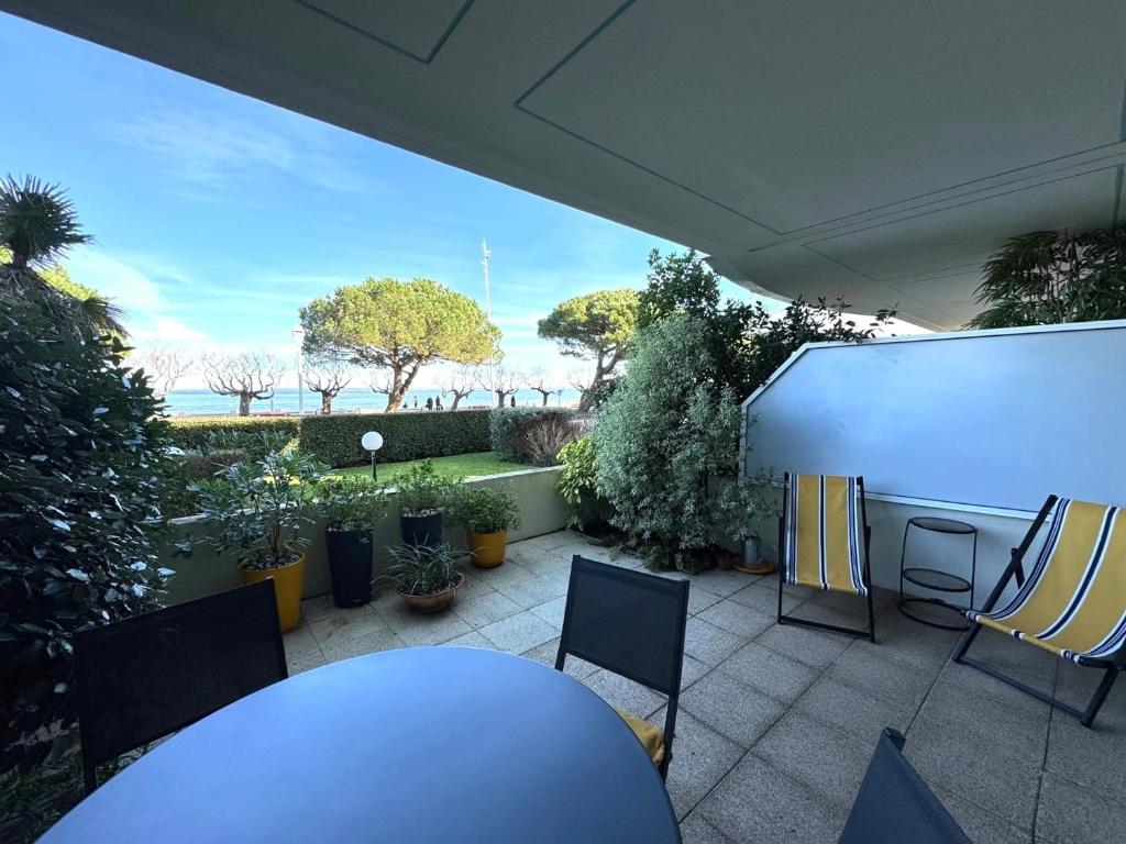 eine Terrasse mit Tisch, Stühlen und Pflanzen in der Unterkunft Studio moderne avec terrasse vue plage et parking à Arcachon - FR-1-474-205 in Arcachon